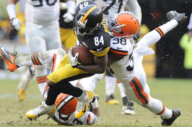 Cleveland Browns defensive back Julian Posey (38) tackles Pittsburgh Steelers wide receiver Antonio Brown (84) after Brown caught a pass in the third quarter of an NFL football game on Sunday, Dec. 29, 2013, in Pittsburgh. (AP Photo/Don Wright)