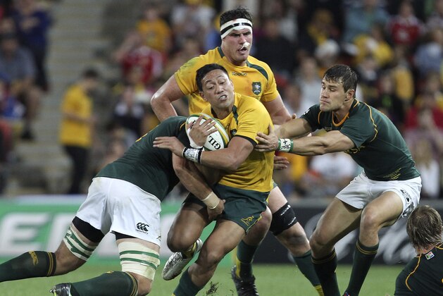 Christian Leali'ifano, center, of Australia is tackled by JJ Engelbrecht of South Africa, right, during their Rugby Championship match in Brisbane, Australia, Saturday, Sept. 7 2013. (AP Photo/Tertius Pickard)