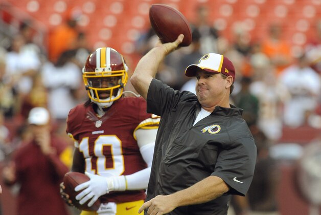 Washington Redskins quarterback Robert Griffin III (10) watches as head coach Jay Gruden throws a pass during warm ups before an NFL preseason football game against the Cleveland Browns Monday, Aug. 18, 2014, in Landover, Md. (AP Photo/Richard Lipski)