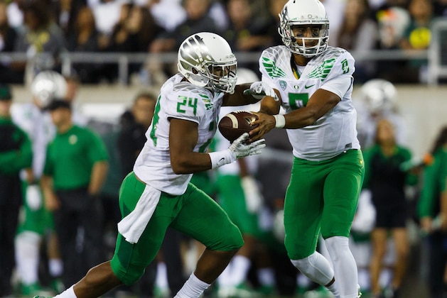Oregon quarterback Marcus Mariota (8) hands off to running back Thomas Tyner (24) during the second quarter of an NCAA college football game against South Dakota in Eugene, Ore., Saturday, Aug. 30, 2014. (AP Photo/Ryan Kang)