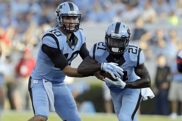 North Carolina quarterback Mitch Trubisky (10) hands off to Romar Morris (21) during the first half of an NCAA college football game against Liberty in Chapel Hill, N.C., Saturday, Aug. 30, 2014. (AP Photo/Gerry Broome)
