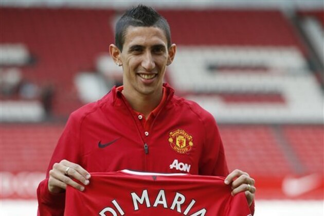 Manchester United's new player Angel Di Maria poses for photographers holding his new shirt, at Old Trafford Stadium in Manchester, England, Thursday, Aug. 28, 2014. Manchester United have signed winger Angel Di Maria from Real Madrid for a British record transfer fee of £59.7m. The Argentine winger had a medical in Manchester on Tuesday and has signed a five-year deal. (AP Photo/Alastair Grant)