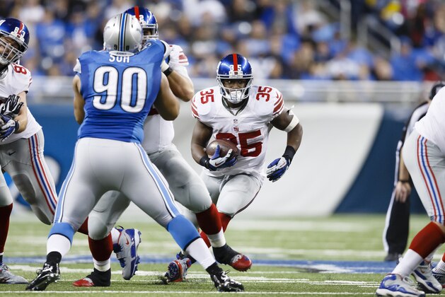 New York Giants running back Andre Brown (35) runs the ball as Detroit Lions defensive tackle Ndamukong Suh (90) is blocked during an NFL football game at Ford Field in Detroit, Sunday, Dec. 22, 2013. (AP Photo/Rick Osentoski)