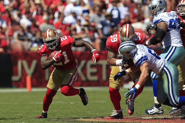 San Francisco 49ers' running back Frank Gore (21) runs as guard Jonathan Goodwin (59) blocks Dallas Cowboys' linebacker Keith Brooking (51) in an NFL football game in San Francisco, Sunday, Sept. 18, 2011. (AP Photo/Marcio Jose Sanchez)