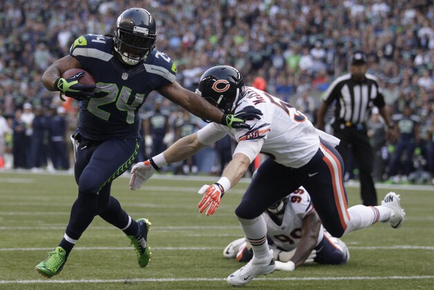 Seattle Seahawks running back Marshawn Lynch runs past  Chicago Bears linebacker Shea McClellin in the first half of a preseason NFL football game, Friday, Aug. 22, 2014, in Seattle. (AP Photo/Stephen Brashear)