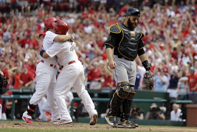 Pittsburgh Pirates catcher Russell Martin, right, walks away as St. Louis Cardinals' Daniel Descalso, left, and Yadier Molina celebrate after Molina scored the game winning run during the ninth inning of a baseball game Wednesday, Sept. 3, 2014, in St. Louis. The Cardinals won 1-0. (AP Photo/Jeff Roberson)