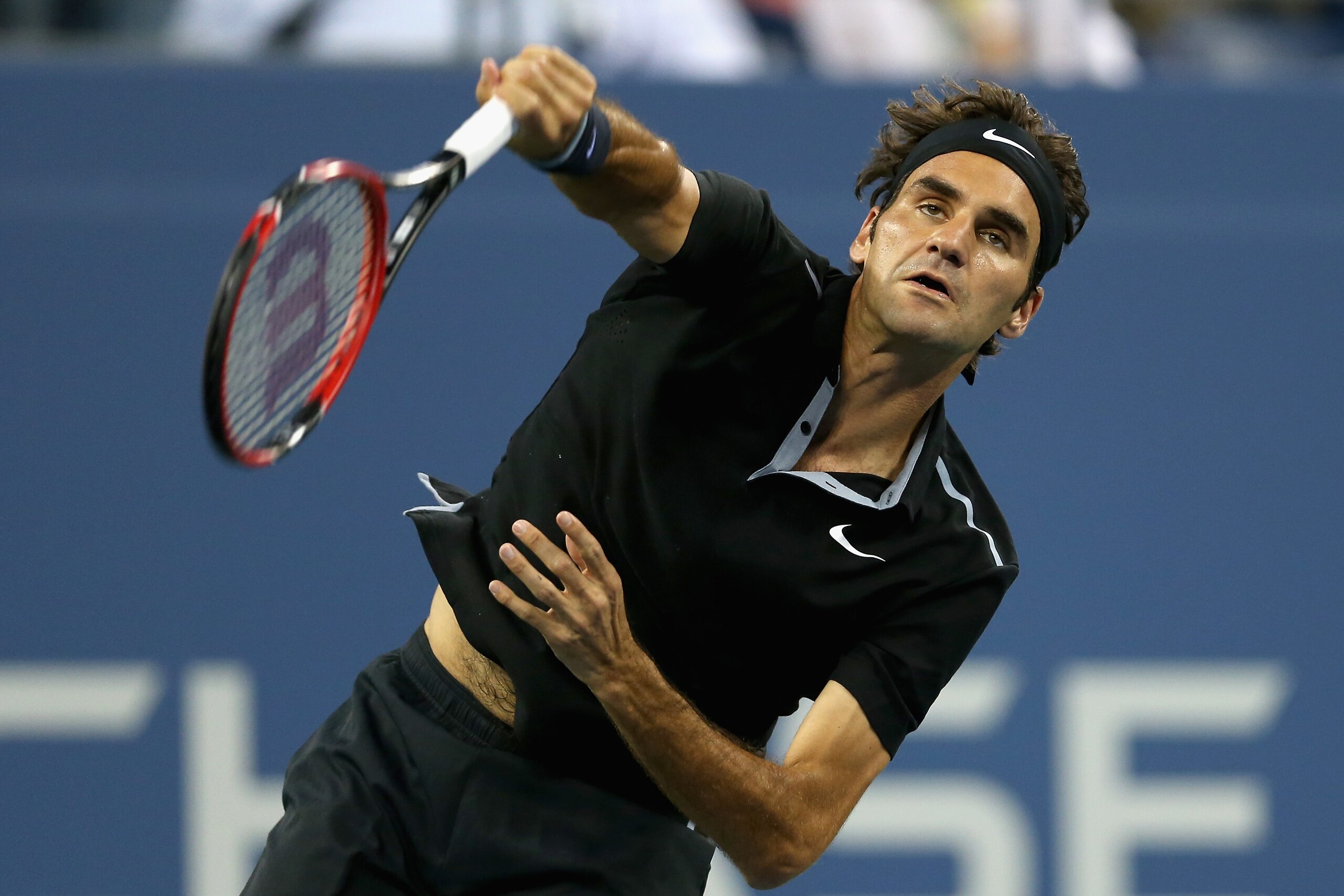 NEW YORK, NY - SEPTEMBER 02:  Roger Federer of Switzerland serves to Roberto Bautista Agut of Spain during their men's singles fourth round match on Day Nine of the 2014 US Open at the USTA Billie Jean King National Tennis Center on September 2, 2014 in the Flushing neighborhood of the Queens borough of New York City.  (Photo by Matthew Stockman/Getty Images)