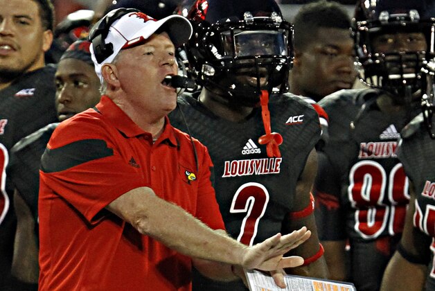 Louisville coach Bobby Petrino shouts instructions to his team during the first half of a NCAA college football game against Miami in Louisville, Ky., Monday, Sept. 1, 2014. (AP Photo/Garry Jones)