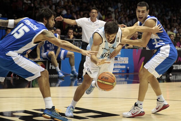 Argentina's Nicolas Laprovittola, center, in action with Greece's Georgios Printezis, left, and Nikos Zisis during the Group B Basketball World Cup match in Seville, Spain, Thursday, Sept. 4, 2014. The 2014 Basketball World Cup competition will take place in various cities in Spain from Aug. 30 through to Sept. 14. (AP Photo/Miguel Angel Morenatti)