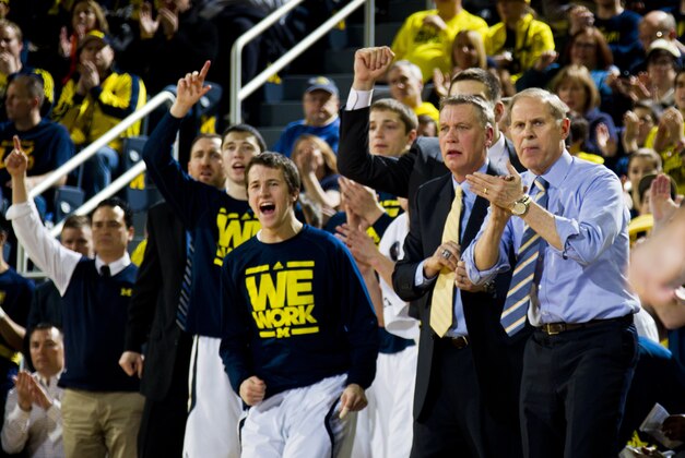 Michigan coach John Beilein, right, and the Michigan bench cheer after a basket during the first half of an NCAA college basketball game against Minnesota at Crisler Center in Ann Arbor, Mich., Saturday, March 1, 2014. Michigan won 66-56. (AP Photo/Tony Ding)