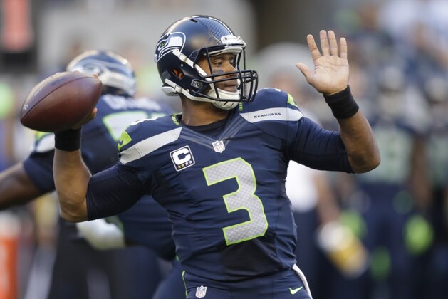 Seattle Seahawks quarterback Russell Wilson winds up to pass against the Green Bay Packers in the first half of an NFL football game, Thursday, Sept. 4, 2014, in Seattle. (AP Photo/Stephen Brashear)