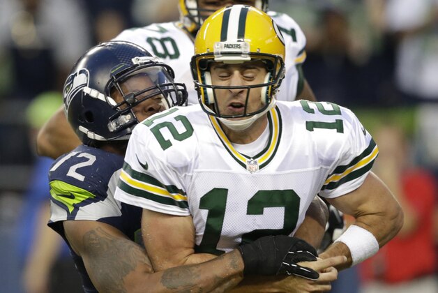 Seattle Seahawks defensive end Michael Bennett forces Green Bay Packers quarterback Aaron Rodgers to fumble in the second half of an NFL football game, Thursday, Sept. 4, 2014, in Seattle. A Packers player recovered the ball in the end zone, but was tackled for a safety on the play. (AP Photo/Scott Eklund)