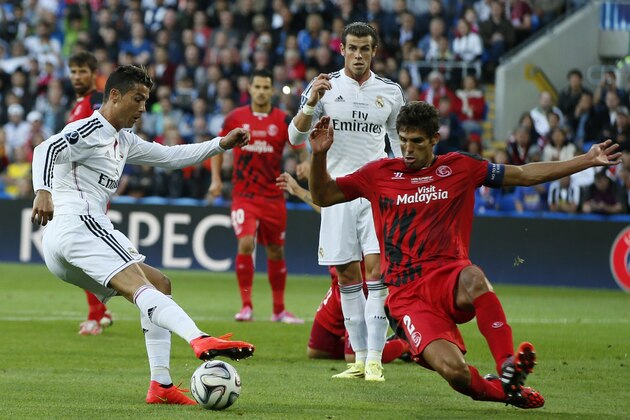 Real Madrid’s Cristiano Ronaldo in action with Sevilla’s Federico Fazio during the UEFA Super Cup soccer match between Real Madrid and Sevilla in Cardiff City Stadium, in Cardiff, Wales, Tuesday, Aug. 12, 2014. (AP Photo/Alastair Grant)