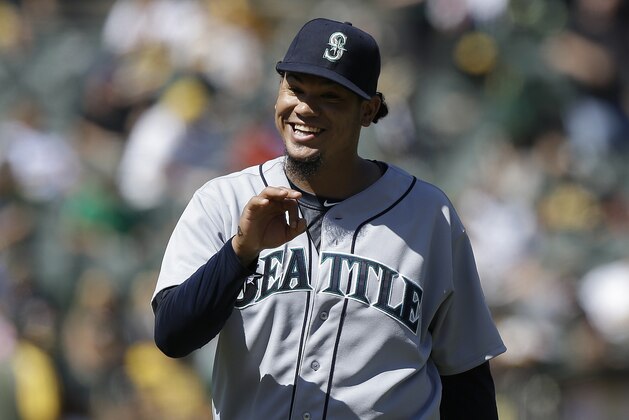 Seattle Mariners pitcher Felix Hernandez smiles as he walks off the mound after the eighth inning of a baseball game against the Oakland Athletics in Oakland, Calif., Wednesday, Sept. 3, 2014. The Mariners won 2-1. (AP Photo/Jeff Chiu)