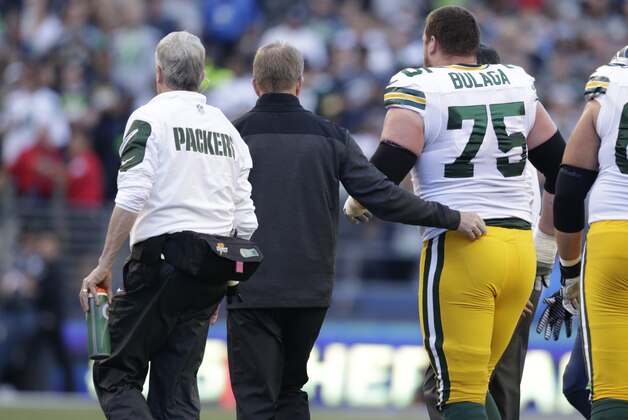 Green Bay Packers' Bryan Bulaga (75) is helped up after an injury in an NFL football game against the Seattle Seahawks, Thursday, Sept. 4, 2014, in Seattle. (AP Photo/Scott Eklund)