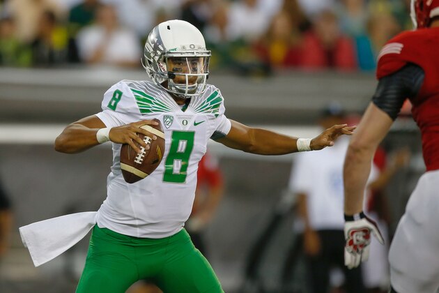 EUGENE, OR - AUGUST 30:  Quarterback Marcus Mariota #8 of the Oregon Ducks rushes against defensive end Drew Iddings #94 of the South Dakota Coyotes at Autzen Stadium on August 30, 2014 in Eugene, Oregon.  (Photo by Otto Greule Jr/Getty Images)