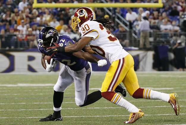 Aug 23, 2014; Baltimore, MD, USA; Baltimore Ravens wide receiver Torrey Smith (82) runs with the ball as Washington Redskins free safety E.J. Biggers (30) defends in the second quarter at M&T Bank Stadium. Mandatory Credit: Amber Searls-USA TODAY Sports