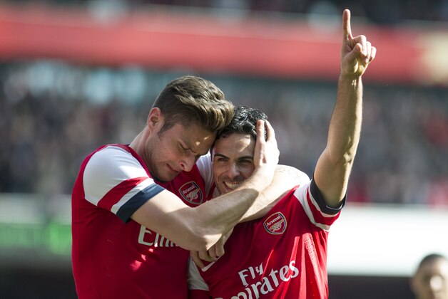 Arsenal's Mikel Arteta celebrates with teammate Olivier Giroud, after scoring against Everton, during their FA Cup quarterfinal soccer match, at Emirates Stadium, in London, Saturday, March 8, 2014. (AP Photo/Bogdan Maran)