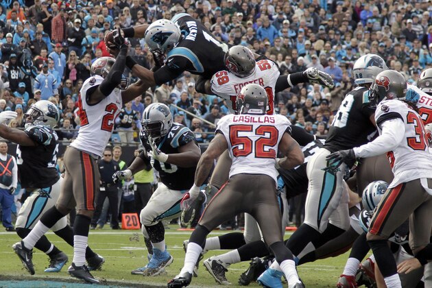 Carolina Panthers' Cam Newton (1) dives over the goal line for a touchdown as Tampa Bay Buccaneers' Darrelle Revis (24) defends in the first half of an NFL football game in Charlotte, N.C., Sunday, Dec. 1, 2013. (AP Photo/Bob Leverone)