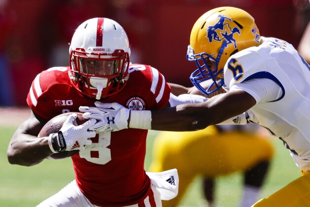 Nebraska running back Ameer Abdullah (8) tries to break a tackle by McNeese State defensive back Brent Spikes (6) in the first half of an NCAA college football game in Lincoln, Neb., Saturday, Sept. 6, 2014. (AP Photo/Nati Harnik)