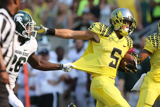 Michigan State's R. J. Williamson, left, tries to hang on to Oregon's Devon Allen after a reception, but Allen broke free for a touchdown during the 2nd quarter of their NCAA college football game in Eugene, Oregon, Saturday Sept. 6, 2014. (AP Photo/Chris Pietsch)