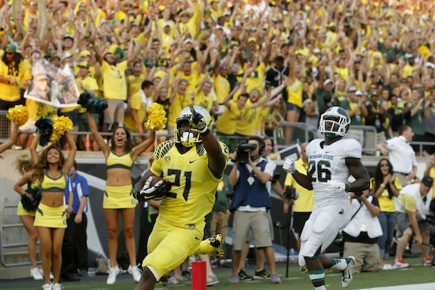 Oregon's Royce Freeman, left, points to the fans after out running Michigan State's R. J. Williamson into the end zone in the 4th quarter of their college football game in Eugene, Oregon, Saturday Sept. 6, 2014. (AP Photo/Chris Pietsch)