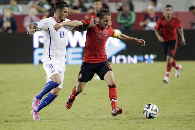 Mexico's Andres Guardado, right, dribbles downfield as Chile's Rodrigo Millar (10) defends during the first half of an international friendly soccer match on Saturday, Sept. 6, 2014, in Santa Clara, Calif. (AP Photo/Marcio Jose Sanchez)