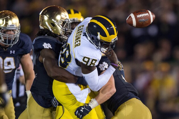 Sep 6, 2014; South Bend, IN, USA; Michigan Wolverines quarterback Devin Gardner (98) fumbles as he is hit by Notre Dame Fighting Irish linebacker Jaylon Smith (9) in the fourth quarter at Notre Dame Stadium. Notre Dame won 31-0. Mandatory Credit: Matt Cashore-USA TODAY Sports