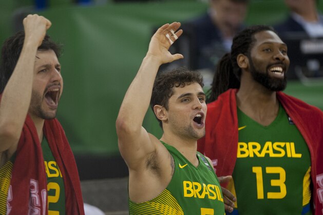 Brazil's Guilherme Giovannoni, left, Raul Togni Neto, center, and Nene Hilario celebrates their victory against Serbia in their Group A Basketball World Cup match in Granada, Spain, Wednesday, Sept. 3, 2014. The 2014 Basketball World Cup competition will take place in various cities in Spain from Aug. 30 through to Sept. 14. (AP Photo/Daniel Tejedor)