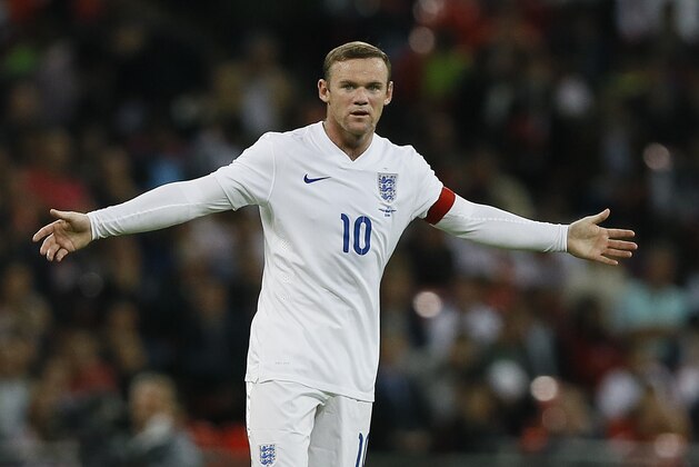 England's captain Wayne Rooney holds out his arms during the international friendly soccer match between England and Norway at Wembley Stadium in London, Wednesday, Sept. 3, 2014. (AP Photo/Kirsty Wigglesworth)