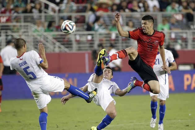 Mexico's Oribe Peralta (19) goes up for the ball as Chile's Gary Medel, center, and Francisco Silva (5)  defend during the first half of an international friendly soccer match on Saturday, Sept. 6, 2014, in Santa Clara, Calif. (AP Photo/Marcio Jose Sanchez)