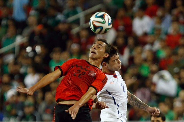 Sep 6, 2014; Santa Clara, CA, USA; Mexico defender Paul Aguilar (22) heads the ball above Chile defender Eugenio Mena (2) during the first half at Levi's Stadium. Mandatory Credit: Kelley L Cox-USA TODAY Sports