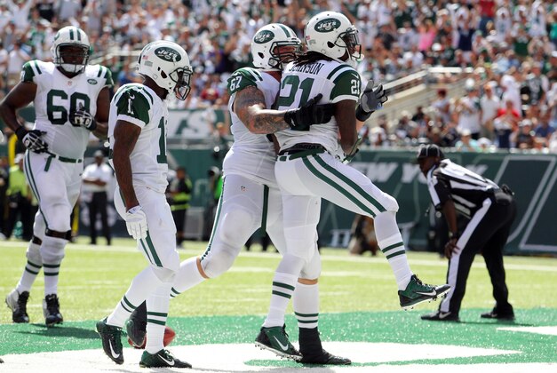 Sep 7, 2014; East Rutherford, NJ, USA; New York Jets running back Chris Johnson (21) celebrates his touchdown against the Oakland Raiders with New York Jets guard Brian Winters (67) during the second quarter of a game at MetLife Stadium. Mandatory Credit: Brad Penner-USA TODAY Sports