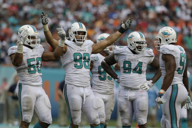 Miami Dolphins defensive tackle Jared Odrick (98) celebrates with the defensive line during the second half of an NFL football game against the Miami Dolphins, in Miami Gardens, Fla., Sunday Sept. 7, 2014. (AP Photo/Wilfredo Lee)