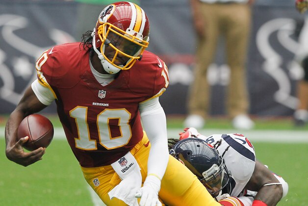 HOUSTON, TX - SEPTEMBER 07:  Robert Griffin III #10 of the Washington Redskins is sacked by D.J. Swearinger #36 of the Houston Texans at Reliant Stadium on September 7, 2014 in Houston, Texas.  (Photo by Bob Levey/Getty Images)