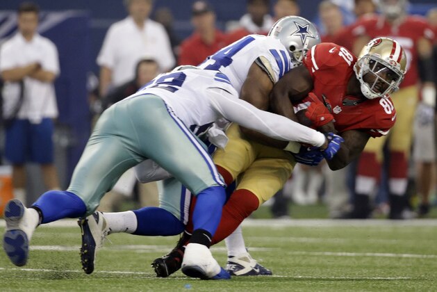 Dallas Cowboys tackle Donald Hawkins (62) and Bruce Carter (54) combine to stop San Francisco 49ers wide receiver Anquan Boldin (81) after Boldin gained yardage following a reception in the first half of an NFL football game, Sunday, Sept. 7, 2014, in Arlington, Texas. (AP Photo/Tony Gutierrez)