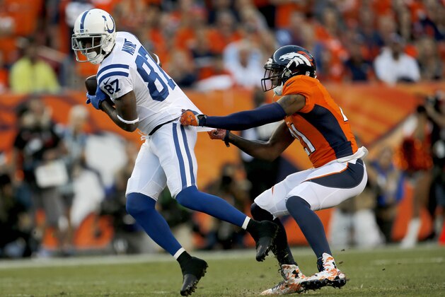 Indianapolis Colts wide receiver Reggie Wayne (87) is stopped by Denver Broncos cornerback Aqib Talib (21) during the first half of an NFL football game, Sunday, Sept. 7, 2014, in Denver. (AP Photo/Joe Mahoney)
