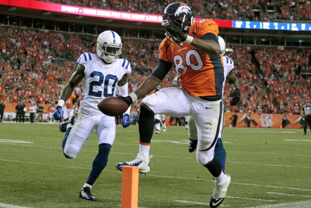 Denver Broncos tight end Julius Thomas (80) scores as Indianapolis Colts free safety Darius Butler (20) approaches during the first half of an NFL football game, Sunday, Sept. 7, 2014, in Denver. (AP Photo/Joe Mahoney)