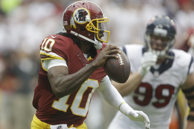 Washington Redskins' Robert Griffin III (10) looks to throw as Houston Texans' J.J. Watt (99) moves in during the first quarter of an NFL football game Sunday, Sept. 7, 2014, in Houston. (AP Photo/Patric Schneider)