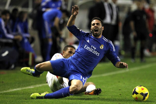 Real Madrid's  Daniel Carvajal, foreground, is tackled by Rayo Vallecano's Nacho Martinez during the Spanish La Liga soccer match between Real Madrid and Rayo Vallecano at the Vallecas stadium in Madrid, Saturday, Nov. 2, 2013. (AP Photo/Francisco Seco)