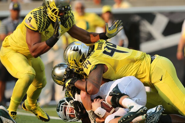 Michigan State's quarterback Conner Cook, bottom, ends up at the bottom of a pile of Oregon Ducks including Arik Armstead, left, Christian French and DeForest Buckner during the 3rd quarter of their college football game in Eugene, OR. Saturday Sept. 6, 2014. (AP Photo/Chris Pietsch)