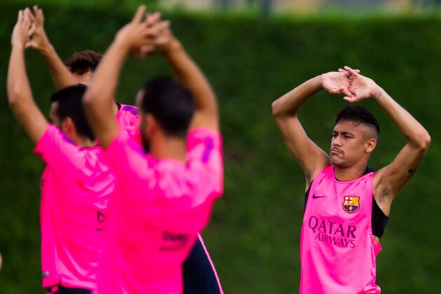BARCELONA, SPAIN - AUGUST 17: Neymar stretches with his teammates during a FC Barcelona training session at Ciutat Esportiva on August 17, 2014 in Barcelona, Spain.  (Photo by Alex Caparros/Getty Images)
