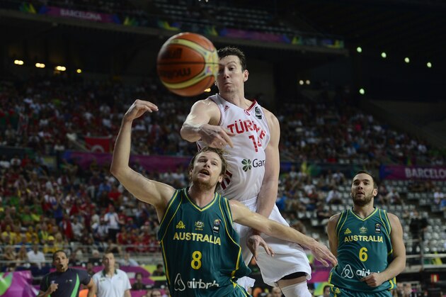 Turkey's Omer Asik, second right, vies for the ball against Australia's Brad Newley during Basketball World Cup Round of 16 match between Turkey and Australia at the Palau Sant Jordi in Barcelona, Spain, Sunday, Sept. 7, 2014. The 2014 Basketball World Cup competition will take place in various cities in Spain from Aug. 30 through to Sept. 14. (AP Photo/Manu Fernandez)