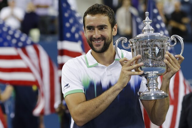 Marin Cilic, of Croatia, holds up the championship trophy after defeating Kei Nishikori, of Japan, in the championship match of the 2014 U.S. Open tennis tournament, Monday, Sept. 8, 2014, in New York. (AP Photo/Darron Cummings)