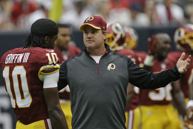 FILE - In this Sept. 7, 2014, file photo, Washington Redskins head coach Jay Gruden talks to quarterback Robert Griffin III  before an NFL football game against the Houston Texans in Houston. Game 1 of the Jay Gruden era with the  Redskins looked a lot like the final games under Mike Shanahan. (AP Photo/David J. Phillip, File)