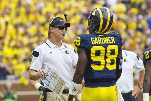 Michigan offensive coordinator Doug Nussmeier, left, gives coaching to quarterback Devin Gardner (98) in the third quarter of an NCAA college football game against Appalachian State in Ann Arbor, Mich., Saturday, Aug. 30, 2014. Michigan won 52-14. (AP Photo/Tony Ding)