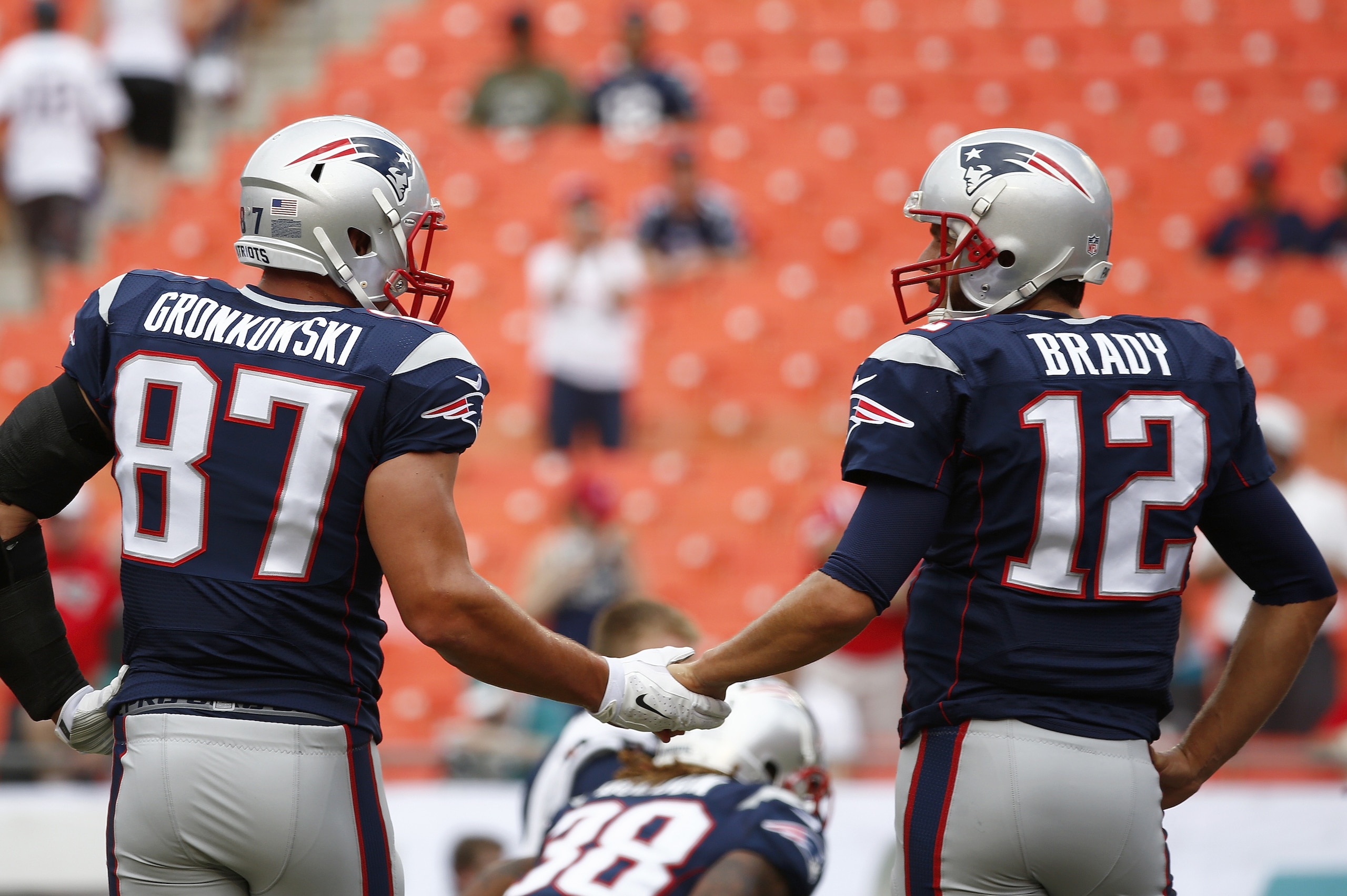 MIAMI GARDENS, FL - SEPTEMBER 07:  Rob Gronkowski #87 of the New England Patriots shakes hands with Tom Brady #12 during pregame workouts before their team met the Miami Dolphins at Sun Life Stadium on September 7, 2014 in Miami Gardens, Florida. Gronkowski has been troubled by a knee injury.  (Photo by Rob Foldy/Getty Images)