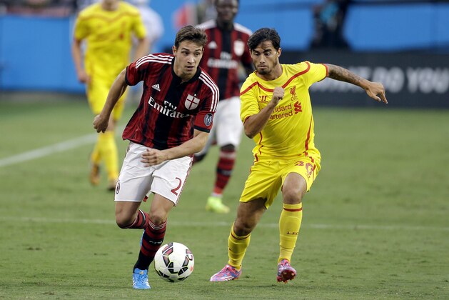 AC Milan's Mattia De Sciglio (2) looks to advance the ball against Liverpool's Suso (30) during a Guinness International Champions Cup soccer match in Charlotte, N.C., Saturday, Aug. 2, 2014. Liverpool won 2-0. (AP Photo/Bob Leverone)