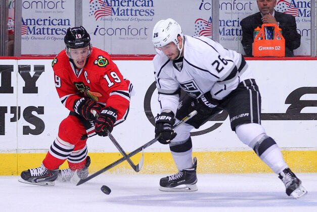 Jun 1, 2014; Chicago, IL, USA; Chicago Blackhawks center Jonathan Toews (19) steals the puck from Los Angeles Kings defenseman Slava Voynov (26) during the second period in game seven of the Western Conference Final of the 2014 Stanley Cup Playoffs at the United Center. Mandatory Credit: Dennis Wierzbicki-USA TODAY Sports