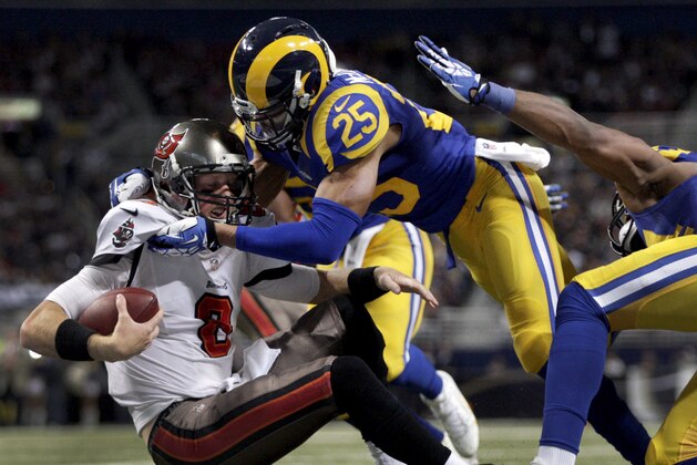 El safety de los Rams, T.J. McDonald (25), derriba al quarterback de los Buccaneers de Tampa Bay, Mike Glennon, en un partido el domingo, 22 de diciembre de 2013, en San Luis. (AP Photo/Tom Gannam)